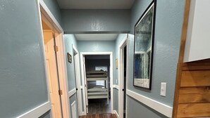 A hallway with wooden flooring, light blue walls, and white trim. - Waterfront, Private dock for 4 boats, Sleeps 13+, Fire Pit, Movie Projector. (Old Town)