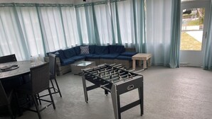 A room with a foosball table, a round table with chairs, a sofa, and a small table. - Waterfront, Private dock for 4 boats, Sleeps 13+, Fire Pit, Movie Projector. (Old Town)
