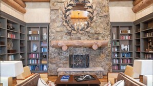 A cozy library with bookshelves, a fireplace, and comfortable seating. -  Bachelors Gulch Condo- 2 Bed and 2 1/2 bath. (Avon)