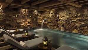 A stone-walled indoor pool area with a waterfall feature, lounge chairs, and lanterns. -  Bachelors Gulch Condo- 2 Bed and 2 1/2 bath. (Avon)