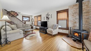 A cozy living room with a fireplace, a sofa, a TV, and a staircase. - Four Seasons Haven (Angola)