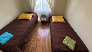 A room with two single beds, each with a pillow and a blanket. - Spacious and Charming Apartment in Iquique. (Iquique)