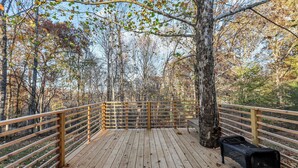A wooden deck with a railing, a bench, and trees in the background. - Tennessee Tranquility • Fire Pit • Forest Views (Ashland City)