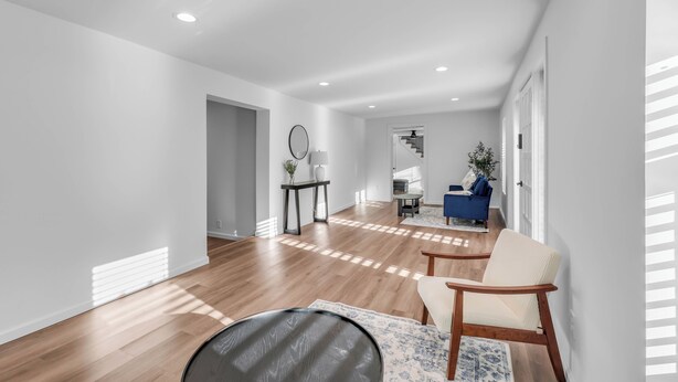 A spacious living area with hardwood flooring, a round coffee table, and a blue sofa. - Tennessee Tranquility • Fire Pit • Forest Views (Ashland City)