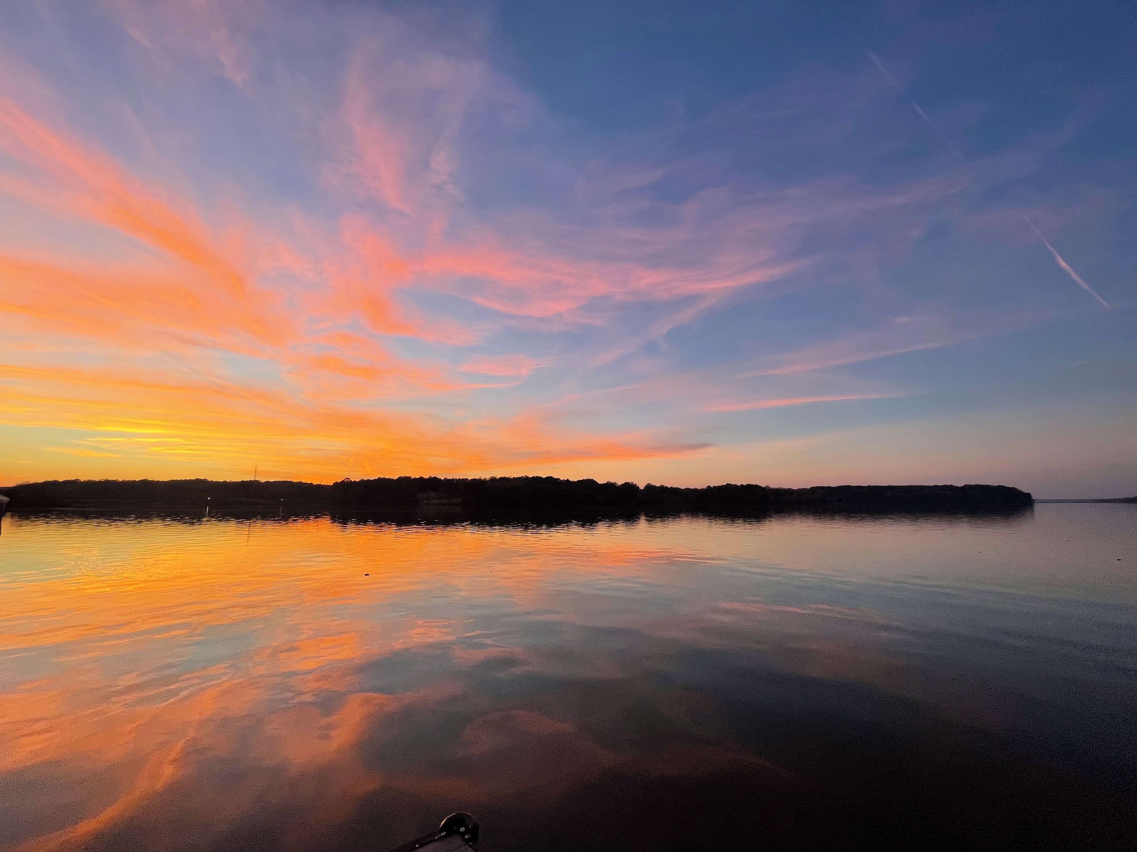 A calm lake with a sunset sky.