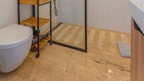 A bathroom with a glass-enclosed shower, a toilet, a wooden shelf, and a sink. - FLH Funchal Studio Blue View Gardens (Funchal)