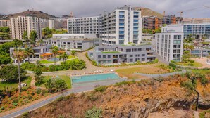 A modern hotel complex with multiple high-rise buildings, a swimming pool, and landscaped gardens. - FLH Ocean View Escape at Acqua Residences (Funchal)
