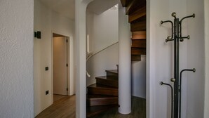 Una escalera de madera con paredes blancas que conduce a una plataforma.