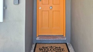 Eine einzelne Tür mit Fußmatte, auf der 'WELCOME' steht.
