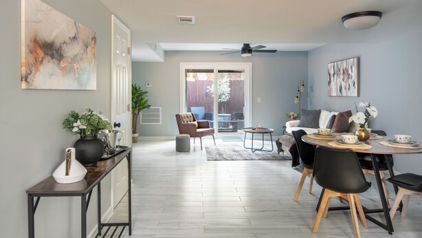 Un salon moderne avec un coin repas, comprenant un canapé, des fauteuils, une table basse et des œuvres d’art accrochées aux murs.