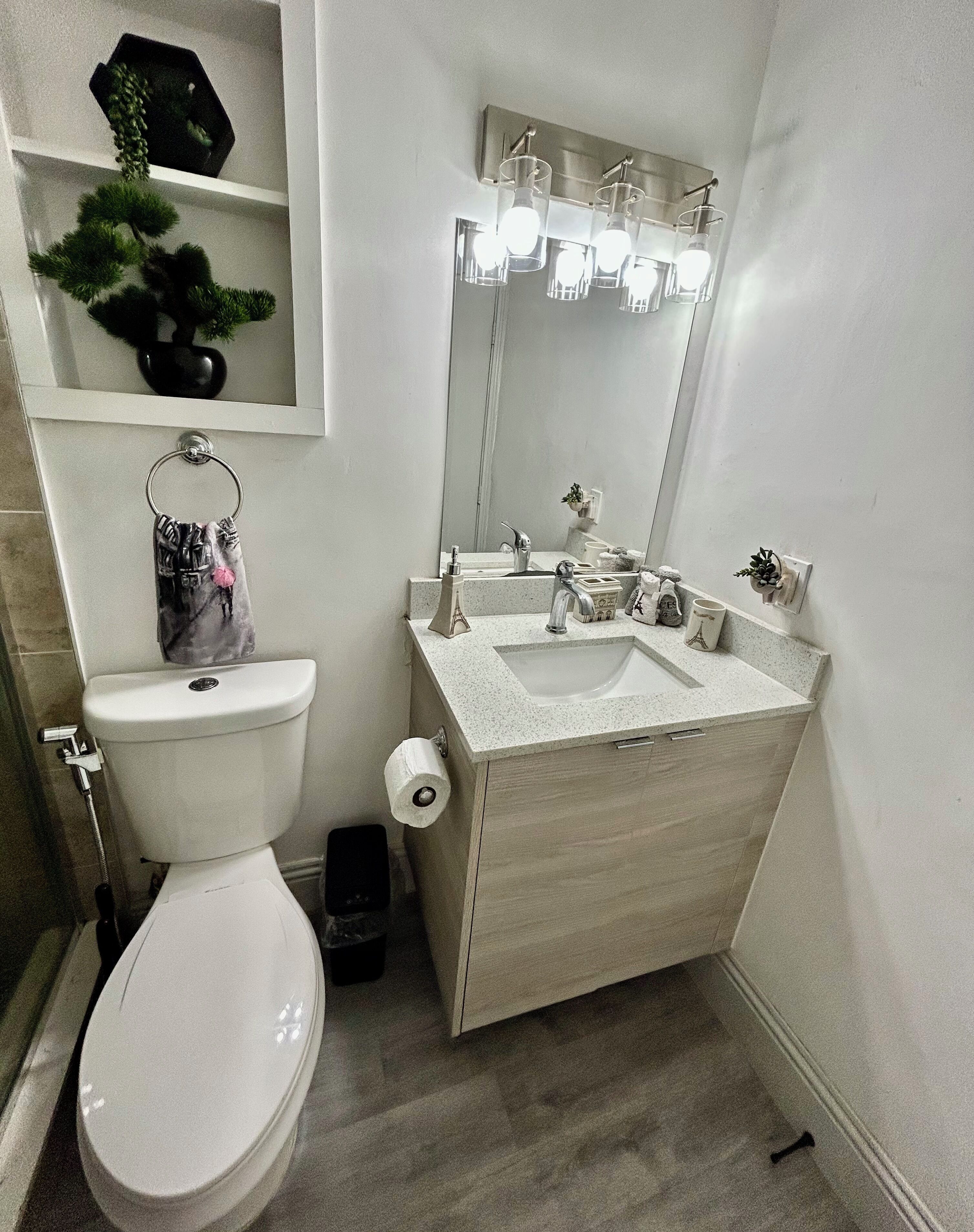 Une salle de bain moderne avec des toilettes, un lavabo et un miroir.