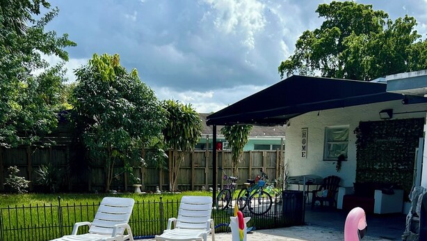 Una piscina con sillones de descanso y juguetes inflables.