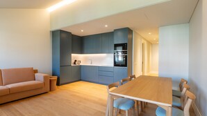 Una cucina moderna con zona pranzo, un divano e un tavolo in legno.