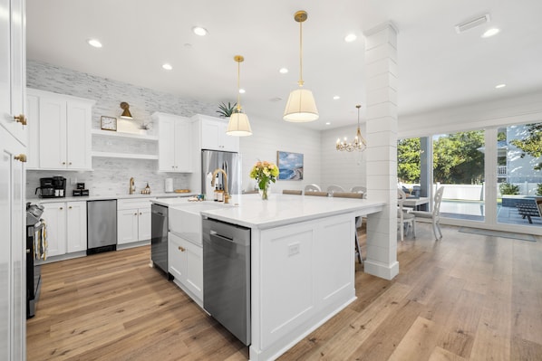 A modern kitchen with white cabinetry, stainless steel appliances, and a large island. - Crystal Sands • 2 Minutes to Beach • Pool & Hot Tub • FREE Golf Cart & Bikes (Destin)