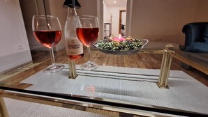 Une table en verre avec deux verres à vin et une bouteille de vin.