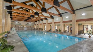 An indoor swimming pool with a tiled floor, wooden beams, and lounge chairs. - WorldMark West Yellowstone condo with easy access to Yellowstone West Gate. (West Yellowstone)