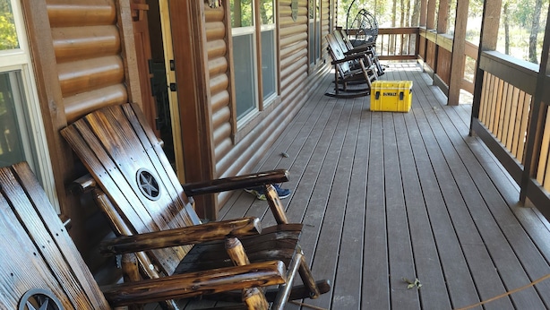 Una terraza de madera con bancos y un estuche amarillo.