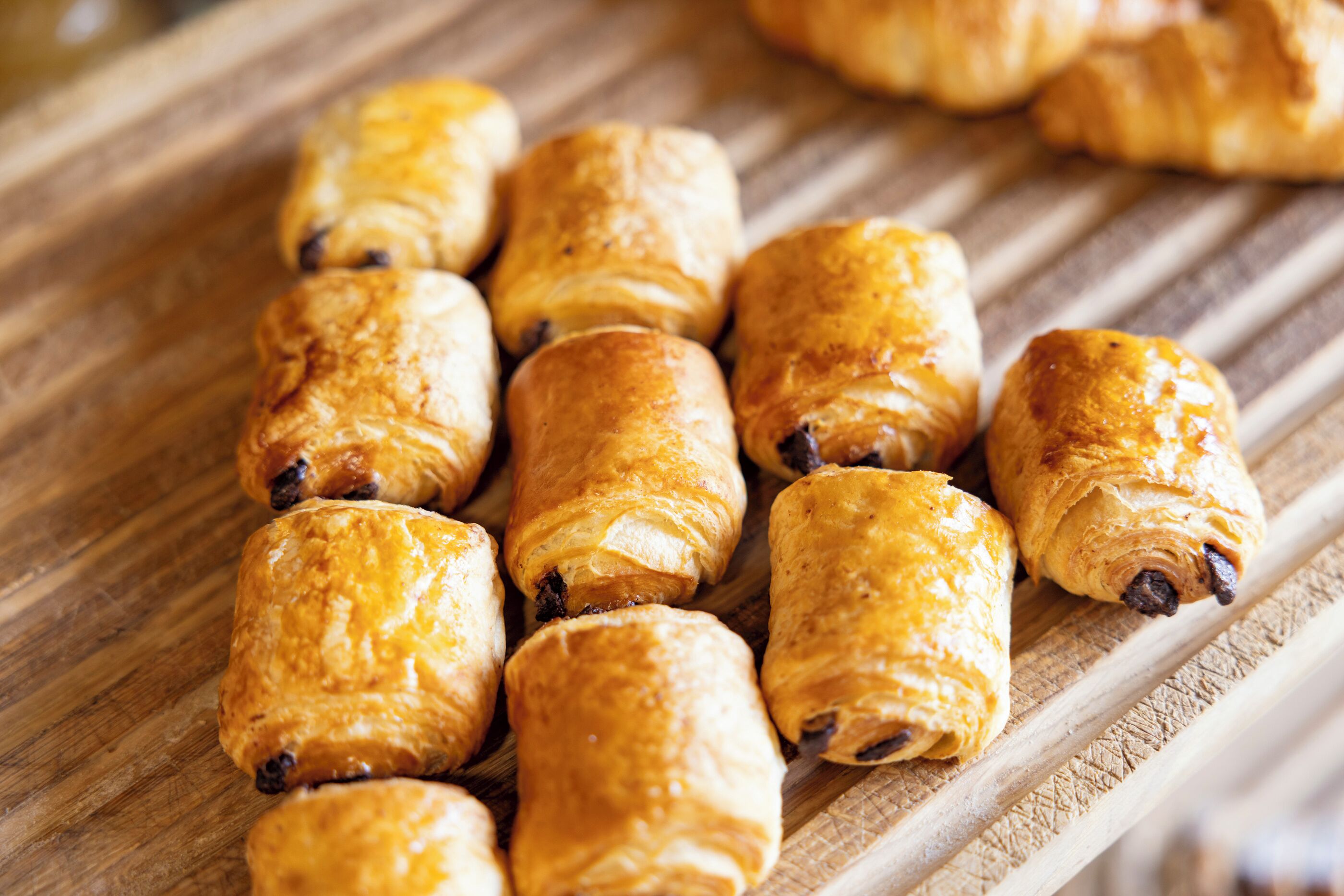 A wooden surface with several golden-brown pastries.