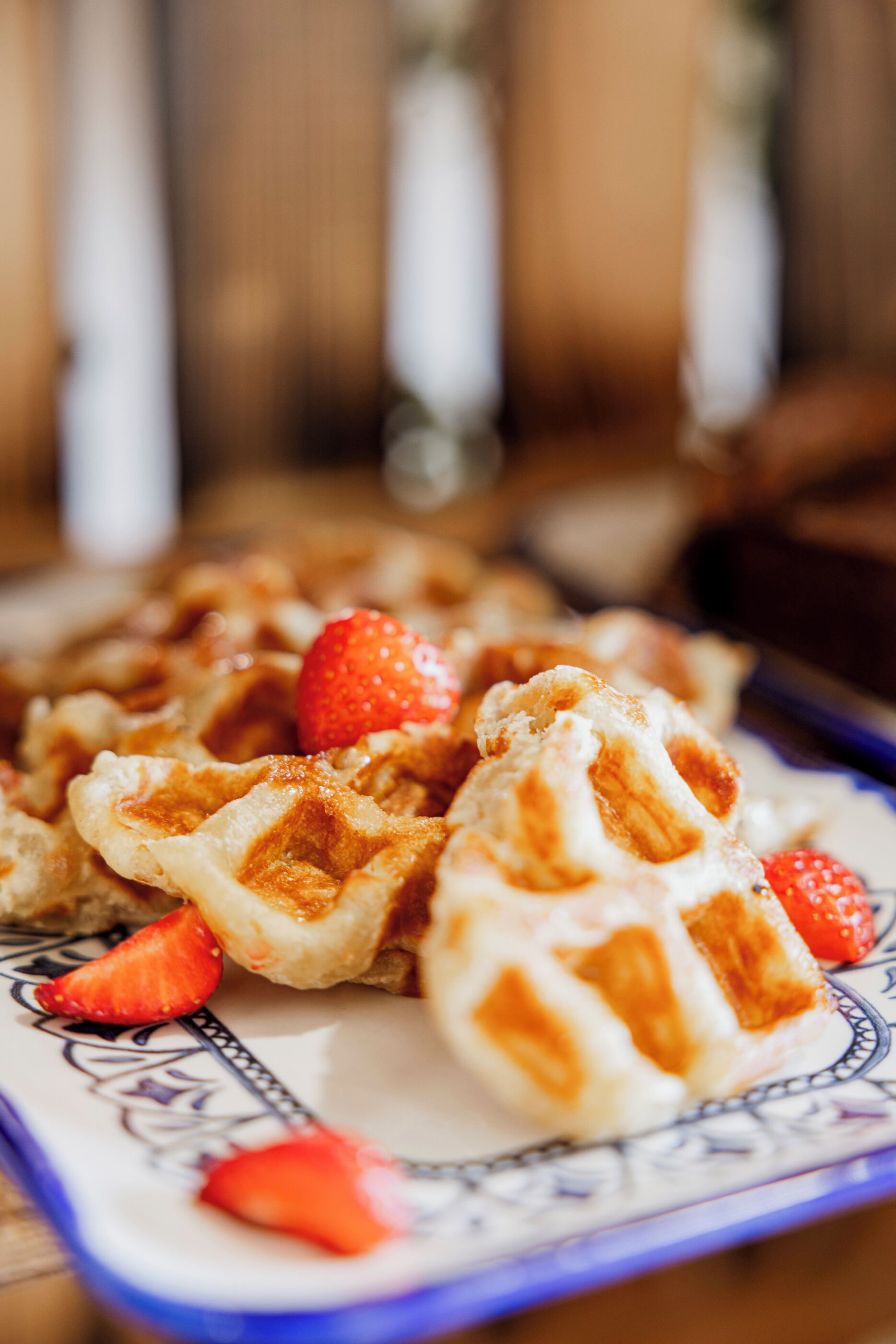 A plate of waffles with strawberries.