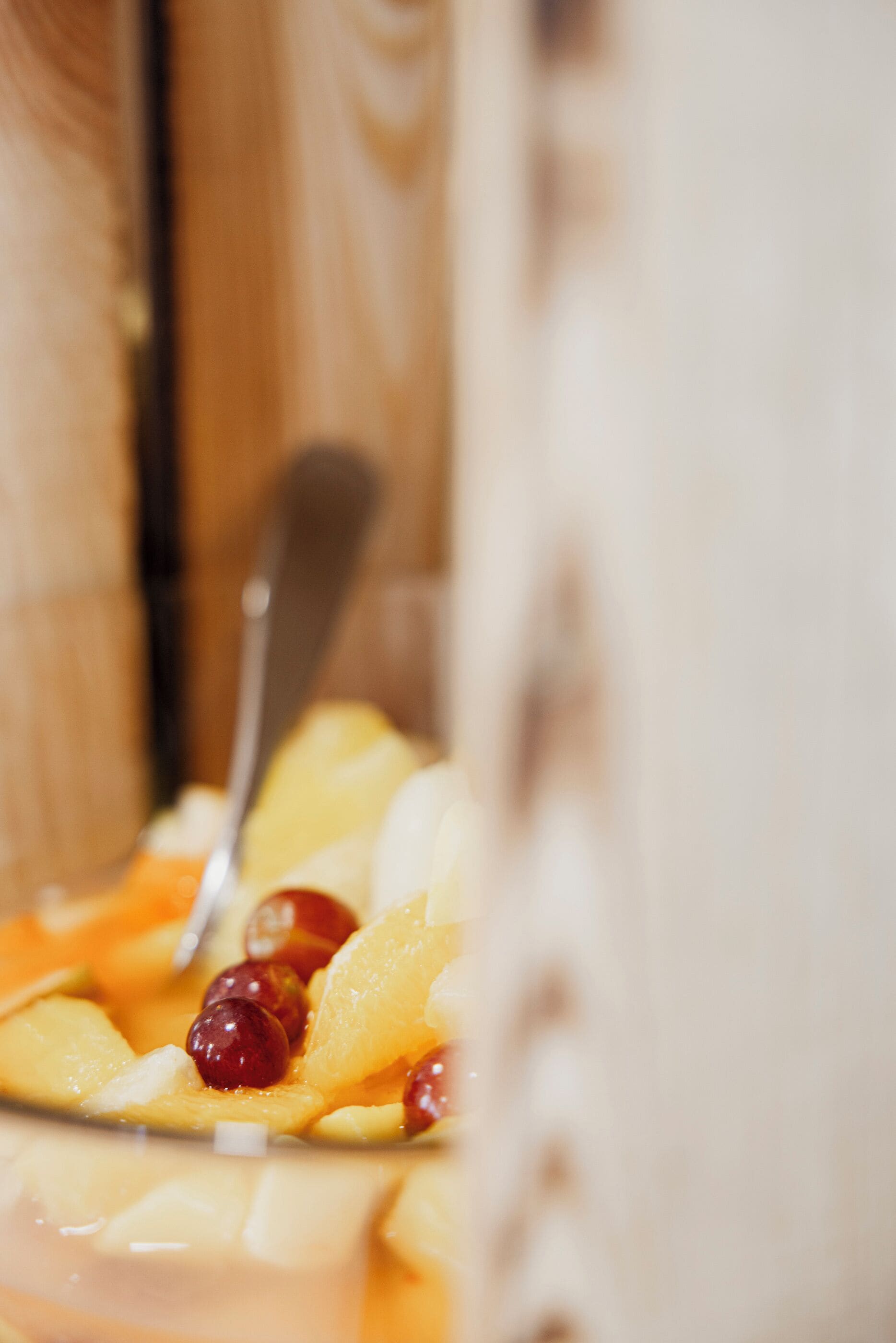 A close-up of a dessert with fruit pieces and a spoon.