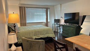 Une chambre d’hôtel de taille réduite, comprenant un lit, un bureau avec un ordinateur, une télévision et une chaise.