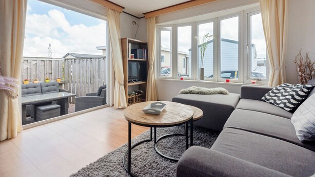 Ett modernt vardagsrum med en soffa, ett soffbord och en tv.