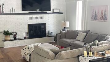 TV connectée, cheminée, table de tennis de table, livres