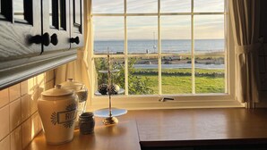 A kitchen with a large window overlooking a grassy area and the sea. - First-Row Beachfront Villa with Stunning Views - Sleeps 16 people+ (Vestfold)