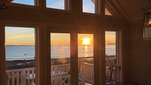 A room with large windows overlooking a balcony with a view of the sunset over the water. - First-Row Beachfront Villa with Stunning Views - Sleeps 16 people+ (Vestfold)