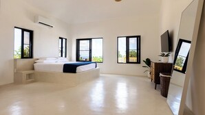 Una camera da letto moderna con un letto, una panca integrata, ampie finestre e una TV.