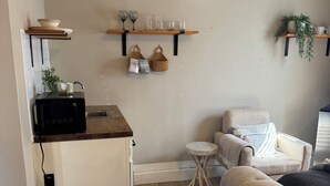 A compact living space with a kitchenette, a sofa, a small round table, and a patterned rug. - Cozy 1-bedroom studio in gorgeous El Paso (El Paso)