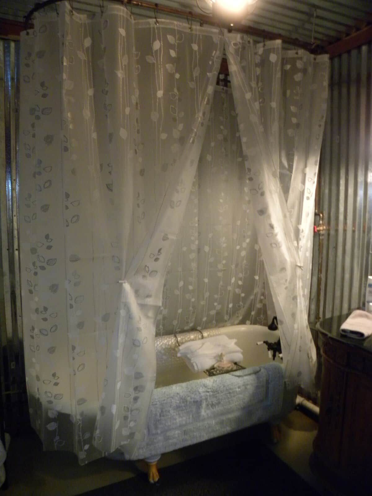 Un lit simple avec un baldaquin, une table de chevet et une petite commode.