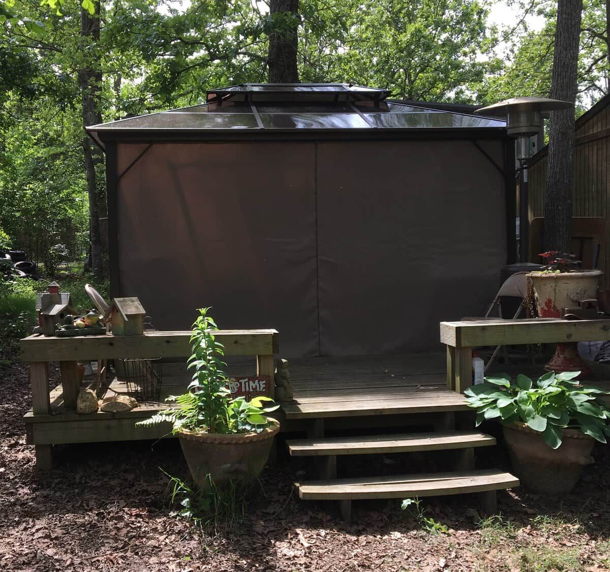 Outdoor cookshack for barbeques with a gas grill, serving table and double sinks