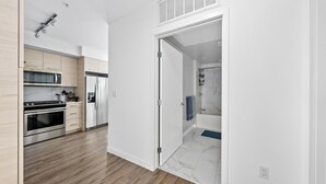 A modern kitchen with stainless steel appliances, wooden cabinets, and a marble backsplash. - Anse Lasio' Penthouse Panoramic Ocean View Rooftop BBQ, Pool and Gym (Santa Monica)