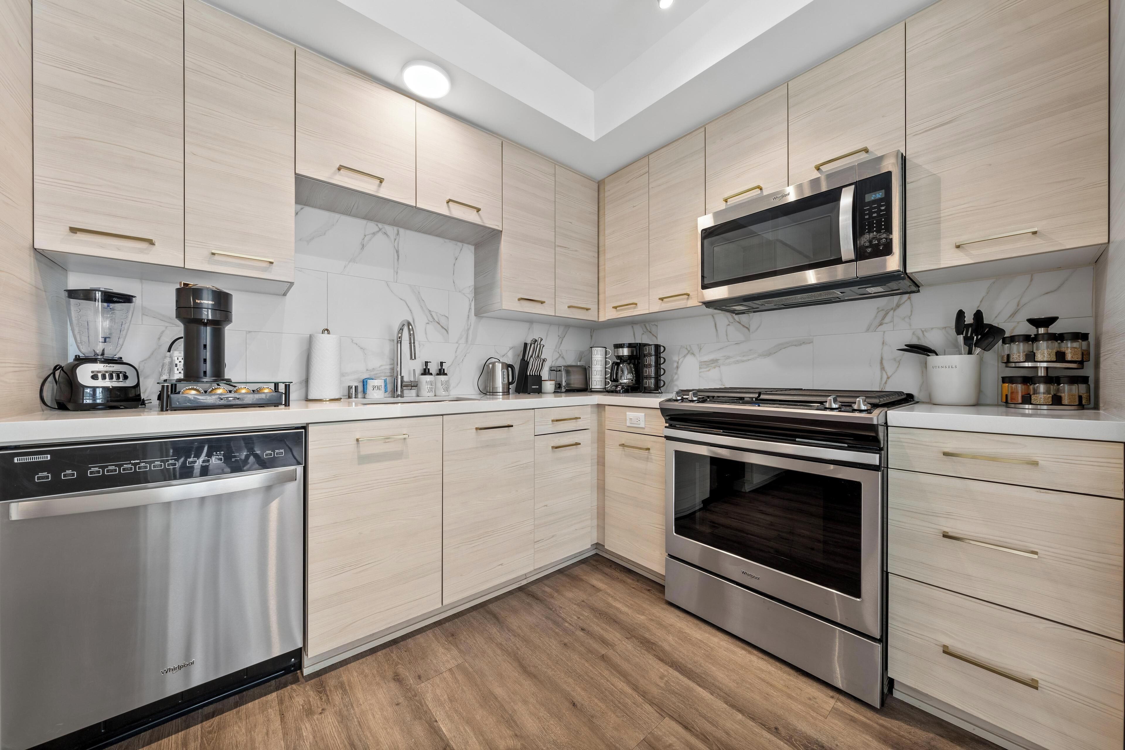 Una cocina moderna con electrodomésticos integrados, armarios de madera y un lavavajillas de acero inoxidable.