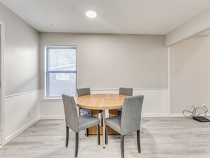 A dining area with a round wooden table and four grey upholstered chairs. - Spacious 3-bedroom house in Tulsa, centrally located (Tulsa)