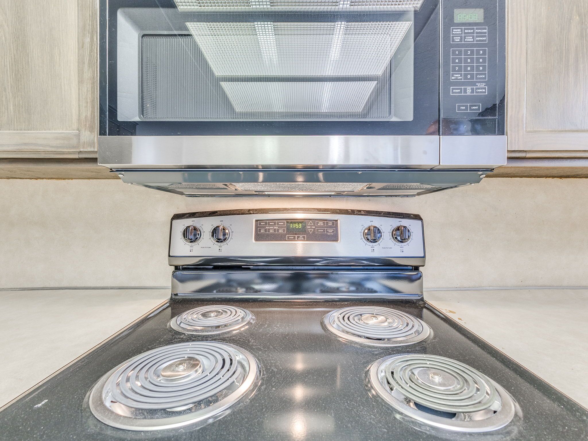 A kitchen with a microwave and a stove with four burners.