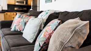 Ein dunkel gefärbtes Sofa mit mehreren Kissen in verschiedenen Mustern.