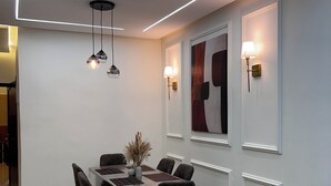 A modern dining area with a rectangular table, six chairs, and pendant lighting. - Belmar Martil - Chic and close to the sea (Martil)