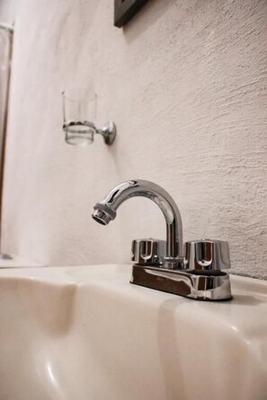 Chuveiro, toalhas de banho, sabonete, shampoo