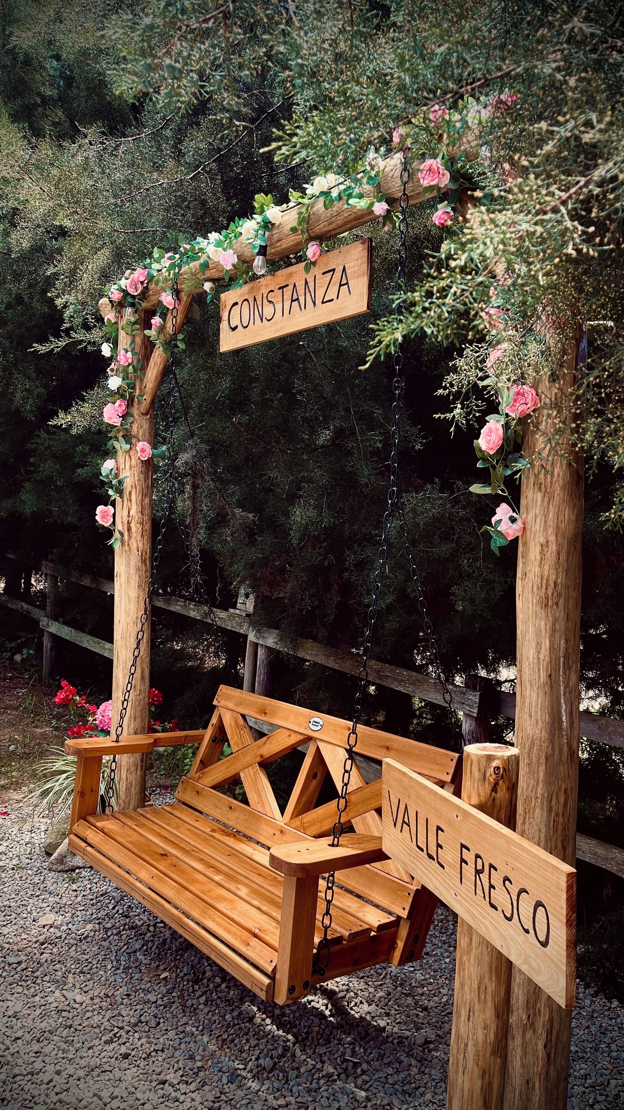 A wooden swing with a sign reading "CONSTANTZA" and "VALLE FRESCO".
