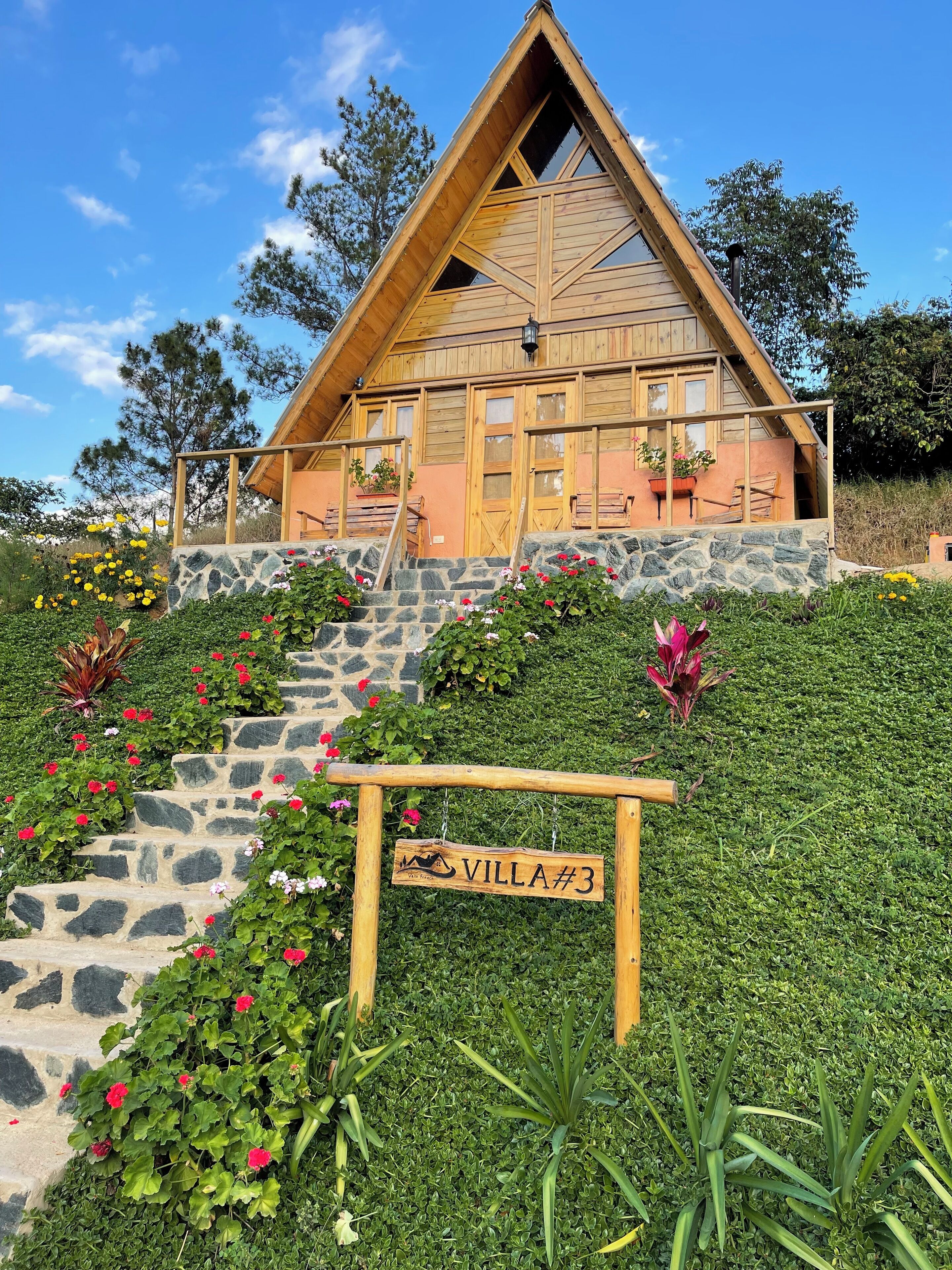 Una villa de madera con una escalera de piedra y un letrero que dice 'Villa #3'.