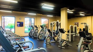 Un gimnasio con cintas de correr, elípticas y máquinas de pesas.