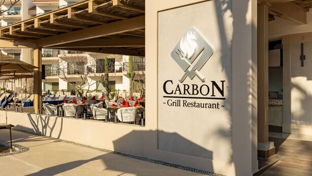 Un restaurante llamado 'CARBON' con terraza y vistas de los edificios circundantes.