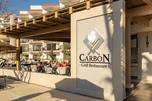 A restaurant named 'CARBON' with outdoor seating and a view of the surrounding buildings. - SPRING BREAK! Fabulous Ocean Front 2-Bed 3-Bath Luxury Medano Beach Resort (Cabo San Lucas)