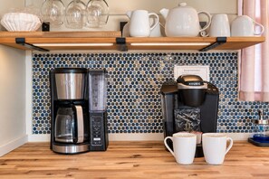 Eine Küche mit Kaffeemaschine, Wasserkocher und einer Tasse auf der Arbeitsfläche.