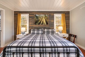 A comfy bed sits between two nightstands with lamps, plus a rack for your suitcase. Unpack your bag and make yourself at home. - FreeDollywoodTix+Pool+Secluded+Modern+HotTub (Sevierville)