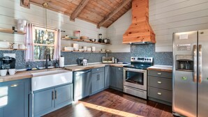 Una cucina moderna con travi in legno, un frigorifero capiente e uno schienale piastrellato.
