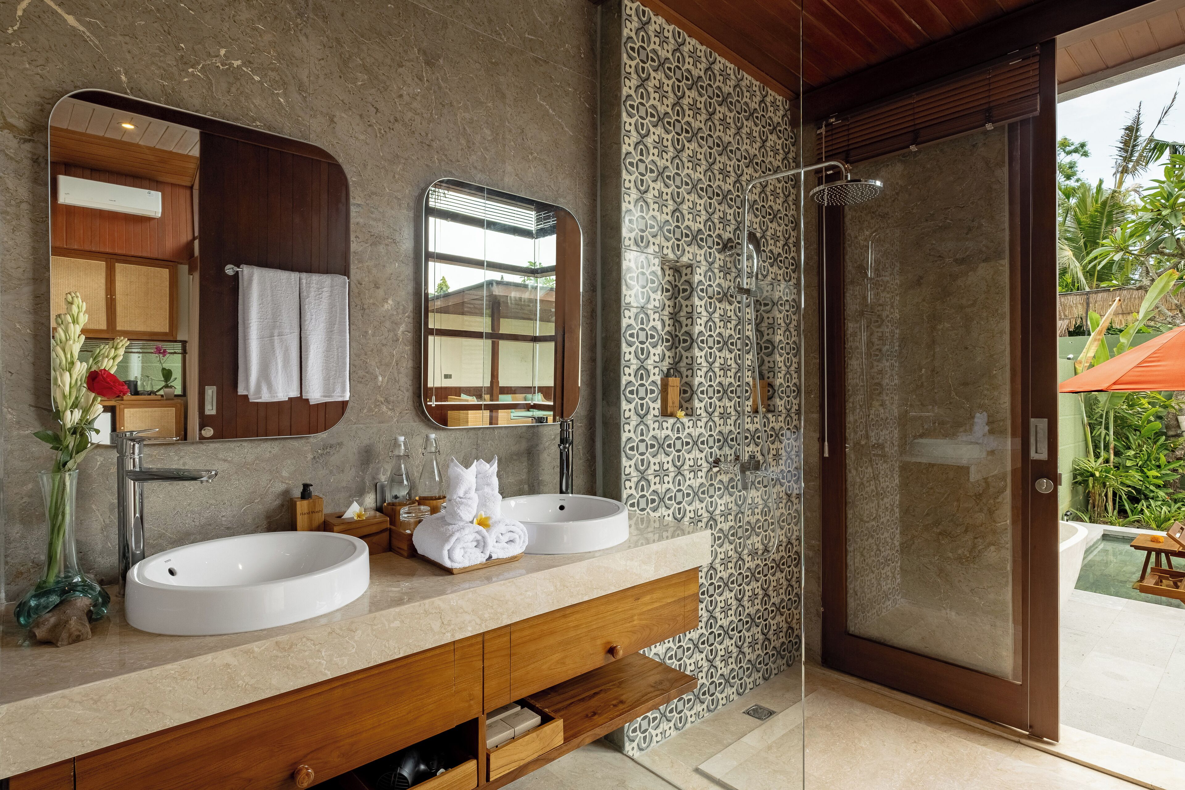 A bathroom with two sinks, a large mirror, and a shower.