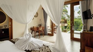 A bedroom with a canopy bed, a desk, and a view of the outdoors. - Orchid Ubud Cottage (Ubud)